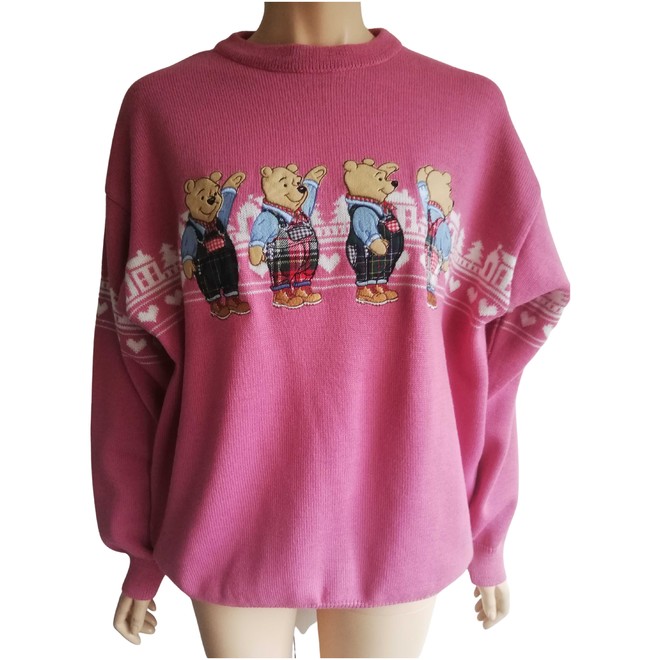 A pink sweater with several embroidered Pooh bears.