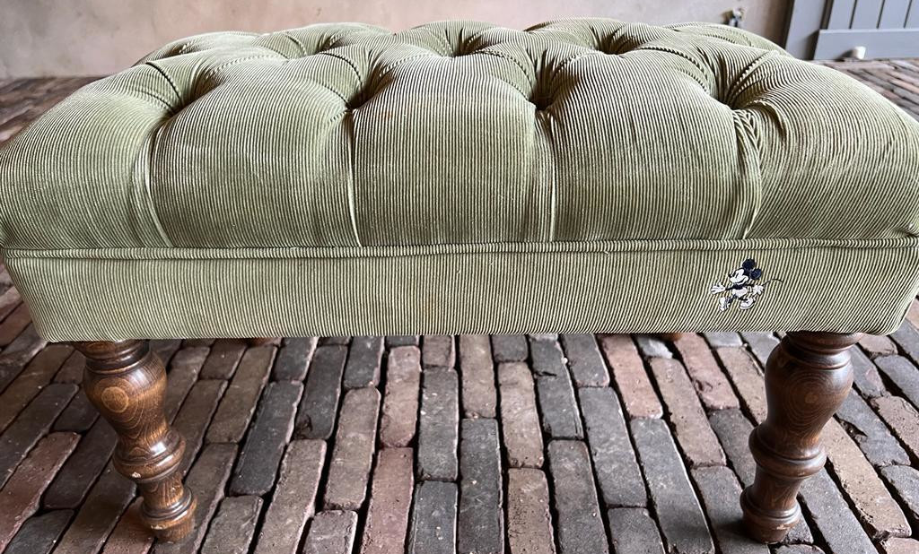 A grey olive footstool.