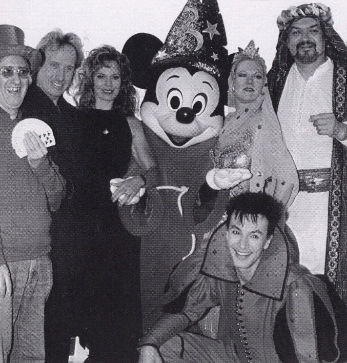 Several magicians surrounding Mickey Mouse