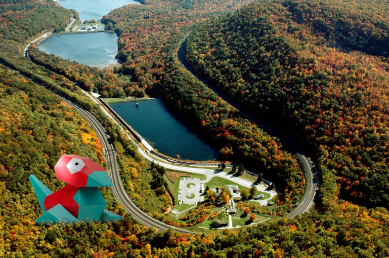 A giant Porygon next to a curved railroad